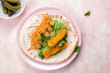 Fish fingers wraps with pea puree and vegetable in tortilla