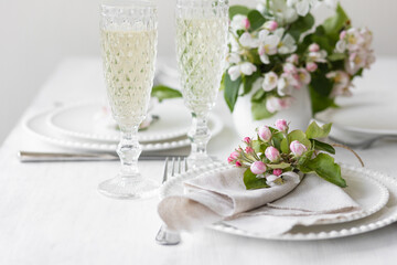 Beautiful table decor for a wedding dinner with a spring blooming apple tree flowers. Celebration...