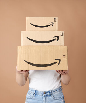 Woman holding Amazon cardboard boxes. Bergamo, Italy, 17 December 2022.