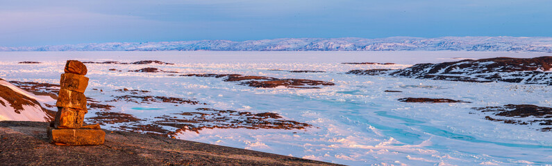 Inukshuk overlooking arctic landscape, Nunavut, Canada.