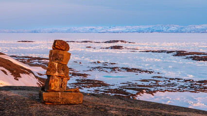 Inukshuk overlooking arctic landscape, Nunavut, Canada.