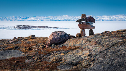 Inukshuk overlooking arctic landscape, Nunavut, Canada.