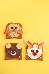 Funny animal faces toasts with spreads, banana, strawberry and blueberry for kids lunch