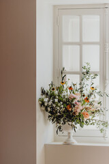 Fototapeta na wymiar Bouquet de fleurs devant la fenêtre