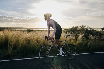 Man rides a gravel bike on the road at sunset.Empty city road.
Sports motivation.Murcia region in...