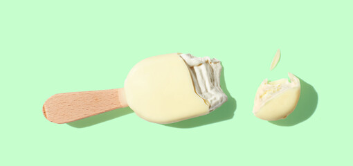 Obraz na płótnie Canvas vanilla ice cream on a stick on green pastel background