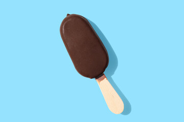 chocolate ice cream on a stick on blue pastel background - obrazy, fototapety, plakaty