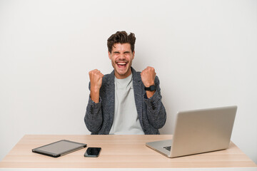 Young entrepreneur man working with a laptop isolated cheering carefree and excited. Victory concept.