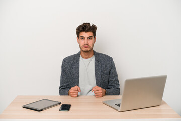 Young entrepreneur man working with a laptop isolated sad, serious face, feeling miserable and displeased.