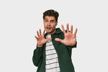 Young handsome caucasian man isolated on white background being shocked due to an imminent danger