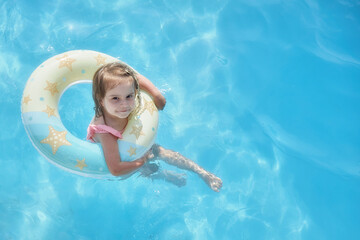 small child swimming with a balloon, view from above.  Summer blue water sunny day