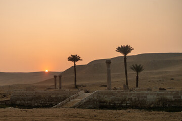 sunset in the desert over ancient Egyptian columns