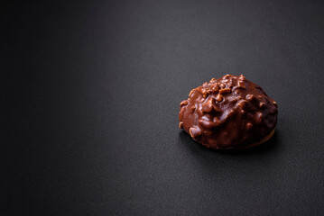 Delicious chocolate tart with nuts on a black ceramic plate