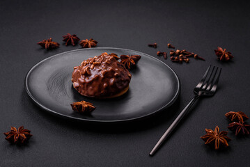 Delicious chocolate tart with nuts on a black ceramic plate