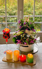 Composition florale avec Jolies fleurs dans un pot et avec des bougies allumées 