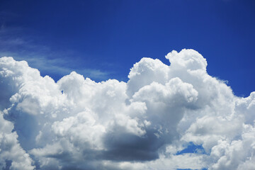 Naklejka na ściany i meble White fluffy clouds. Azure, light blue sky. Background for design. Summer sunny day. Large cumulus clouds. atmospheric front. Weather change. Epic.