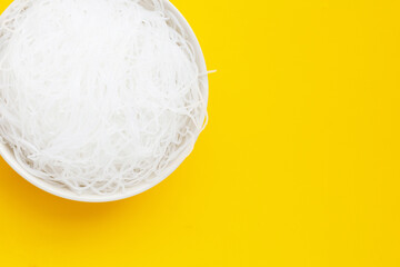 Vermicelli in white bowl on yellow background.