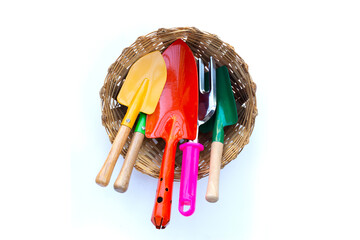 Garden shovel with fork in bamboo basket on white background. Garden tools