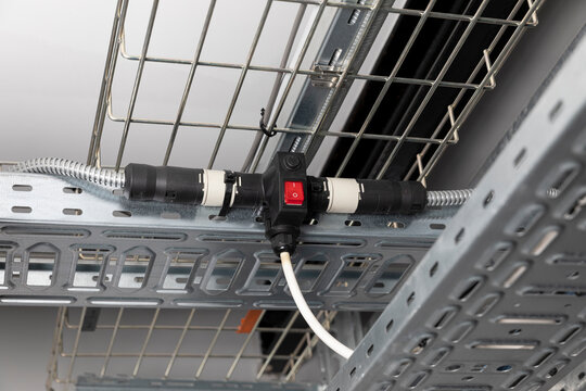 Steel Cable management baskets and trays with modular wiring, T conduit connector, drum of armoured cable, electrical installation