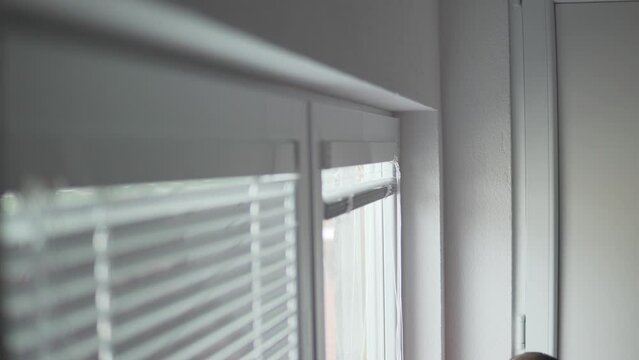 Professional worker man using screw to install the blinds on a pvc window in a house