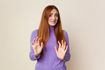 Young red hair woman isolated rejecting someone showing a gesture of disgust.