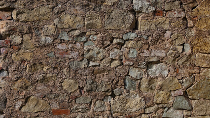 stone wall, in the photo an old brown stone wall close-up