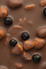 Texture of milk chocolate with nuts and berries