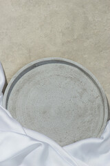 gray tray on a gray stone with a piece of white cloth