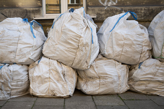 Heavy duty woven polypropylene jumbo rubble sacks filled with debris after construction works left on pavement