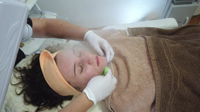 Applying mask and cleansing foam problematic face with acne of young teen girl in dermatology office