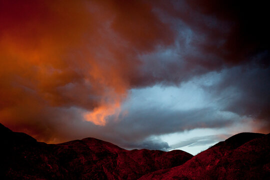 Scenic view of mountain against dramatic sky during sunset