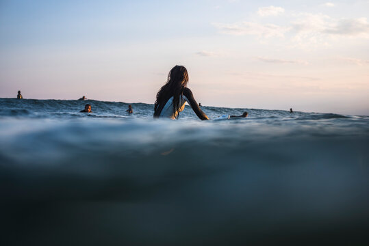 Young Woman waiting for Waves at Golden Hour