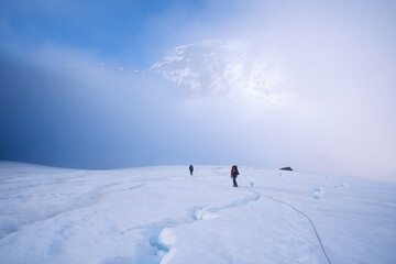 Climbers crossing dangerous crevasses in fog on Mt. Rainier, Washington