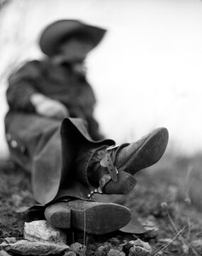 A cowboy portrait of cowboy boots resting out in a field.