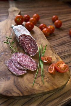 Close up of red sausage stick with tomatoes on a chopping board, Germany