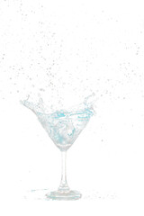 Blue Cocktail Glass with splashing water alcohol, Crystal Cocktail drink splatter splash in air and bubble from glass. Liquor Part freeze shot high speed over black background isolated