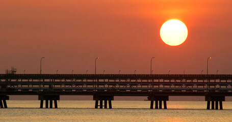 Obraz premium Mesmerizing scenery of a jetty on the ocean during the evening sunset