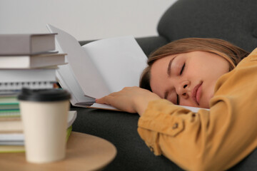 Young tired woman sleeping near books on couch indoors, closeup