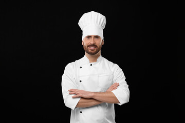 Smiling mature chef on black background, space for text