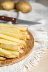 Cut raw potatoes on white table, closeup