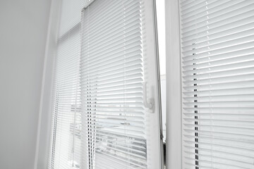 Stylish window with horizontal blinds in room