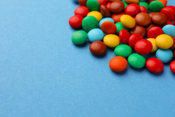 Tasty colorful candies on blue background, space for text