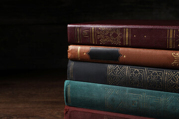 Stack of old hardcover books on wooden table, closeup. Space for text