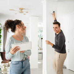 man and woman couple wife husband set up surveillance security camera