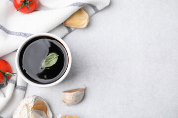 Organic balsamic vinegar and cooking ingredients on white table, flat lay. Space for text