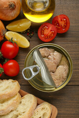 Flat lay composition with tin can of tasty cod liver and different products on wooden table