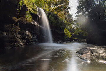 Tropical landscape. Beautiful hidden waterfall in rainforest. Slow shutter speed