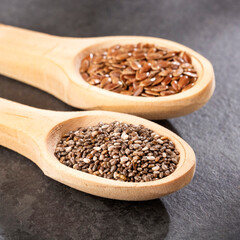 Organic flax and chia seeds in wooden spoons