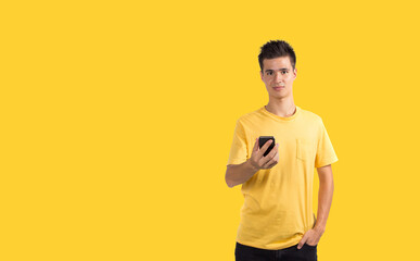 Fototapeta na wymiar Teenage boy using smart phone, isolated on blue background