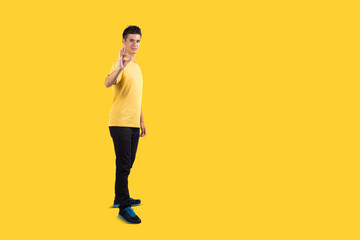 Fototapeta na wymiar Full body Teenage boy portrait wearing casual t-shirt showing sign of ok, isolated on yellow background